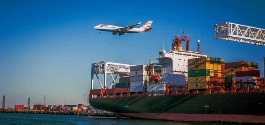 A ship at the port and a plane flying above